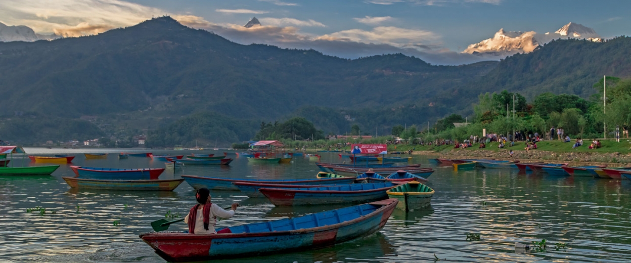 Colourful boats on Phewa Lake beneath the Annapurna mountains